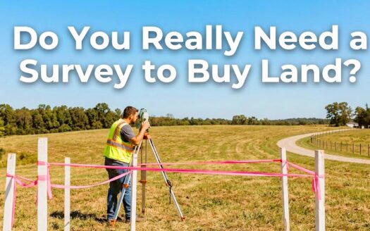 A real estate surveyor using a total station theodolite to measure boundary lines in an open grassy field